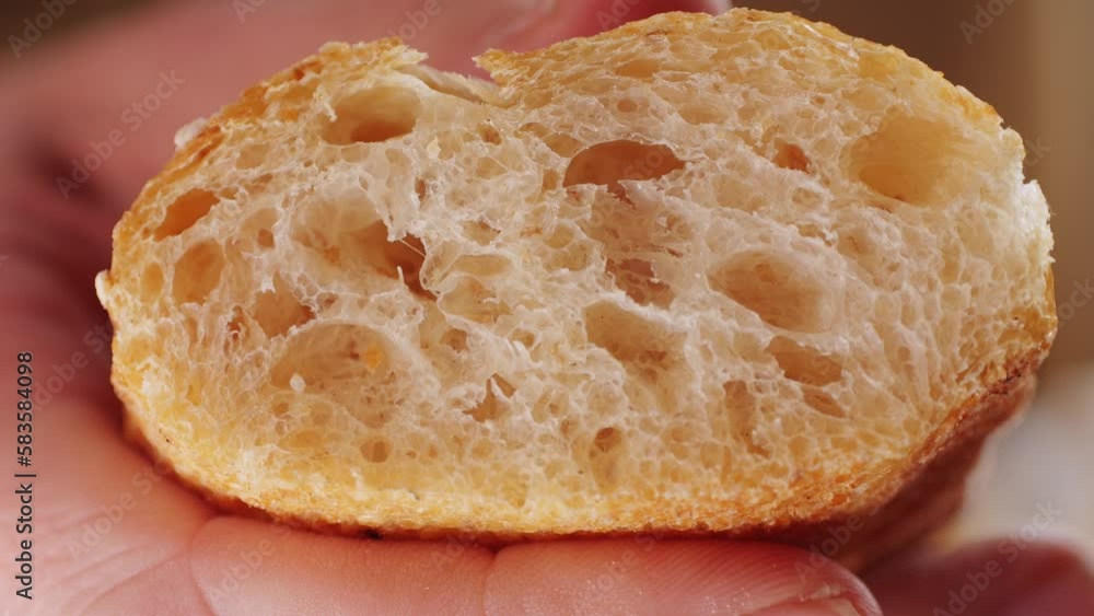 Whole wheat white grain bread close-up macro texture in hands. Man cutting fresh bread with a big knife. Fresh baguette on the kitchen table. Whole wheat white grain bread close-up macro texture in hands. Man cutting fresh bread with a big knife. Fresh baguette on the kitchen table.
