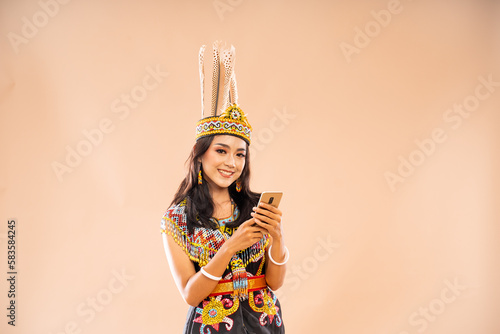 asian woman in king bibinge smiling while using the phone on isolated background photo