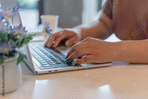 Woman working typing on keyboard laptop computer searching information on keyboard close up. technology digital, online communication, working from home, freelancing, e-commerce,