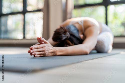 Fitness asian woman doing yoga stretching exercise on mat yoga fitness exercises. Healthy lifestyle Calmness and relax at yoga studio