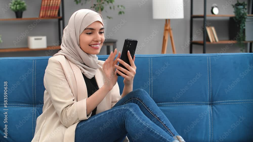Modern Muslim female use mobile phone scrolling social networks multimedia content free time at home Modern Muslim female use mobile phone scrolling social networks multimedia content free time at home