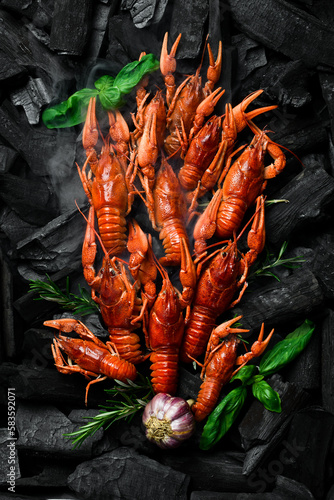 Hot spicy boiled crayfish on hot charcoal. On a charcoal background. Free space for text.