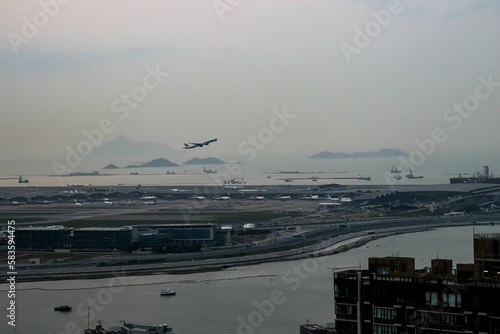 White aircraft flying over Hong Kong International Airport photo