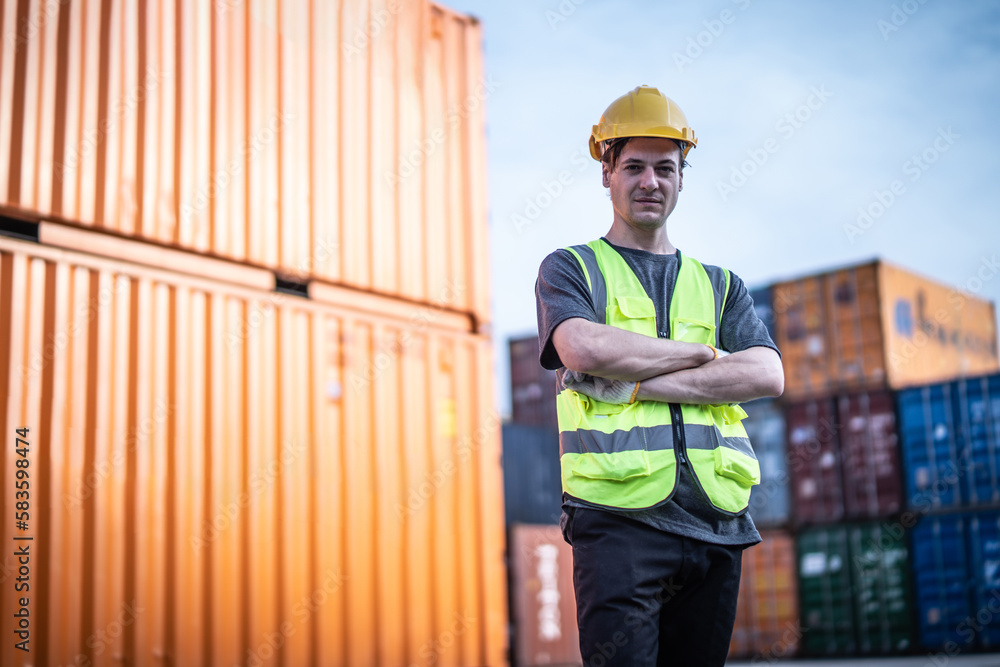 Caucasian warehouse worker in uniform with hard hat standing in container port terminal. Area logistics import export and shipping. Caucasian warehouse worker in uniform with hard hat standing in container port terminal. Area logistics import export and shipping.