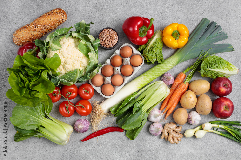 Flat lay of vegetables and fruits on grey background, top view. Healthy eating concept. 