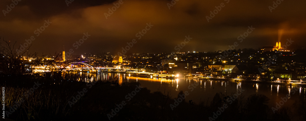 Obraz premium The swimming christmas market 2022 at night with reflections at Vilshofen, Danube, Bavaria, Germany