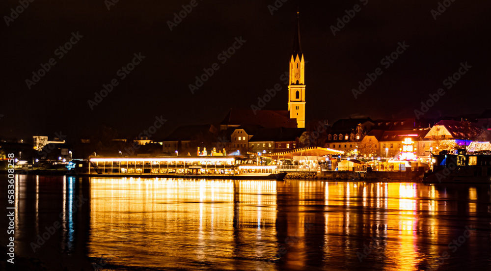 The swimming christmas market 2022 at night with reflections at Vilshofen, Danube, Bavaria, Germany