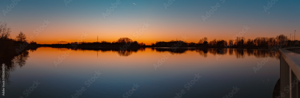 High resolution stitched sunset panorama with reflections near Plattling, Isar, Bavaria, Germany