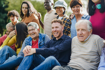 Group of multi generational people having fun together outdoor - Multiracial friends enjoy day at city park
