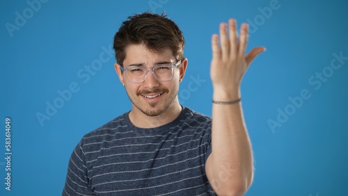 Portrait of young hipster man 20s pointing fingers himself ask say who me no thanks i do not need it isolated on plain blue background in studio
