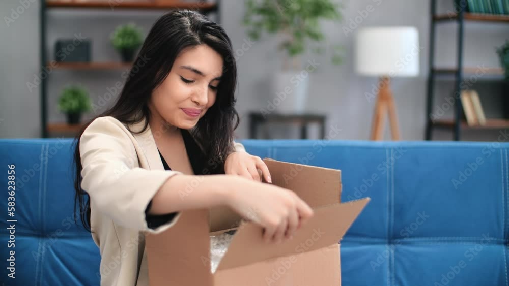 Happy shopaholic female unpacking parcel cardboard box with desired marketplace order at home Happy shopaholic female unpacking parcel cardboard box with desired marketplace order at home