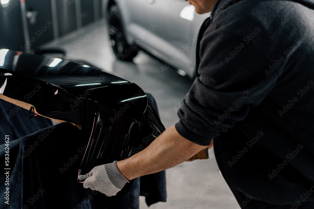 Gluing the film on the spoiler to protect the paint which protects the