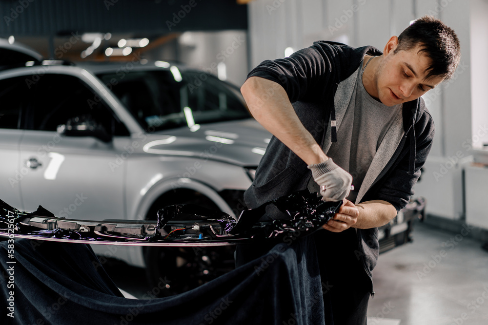 Gluing the film on the spoiler to protect the paint which protects the