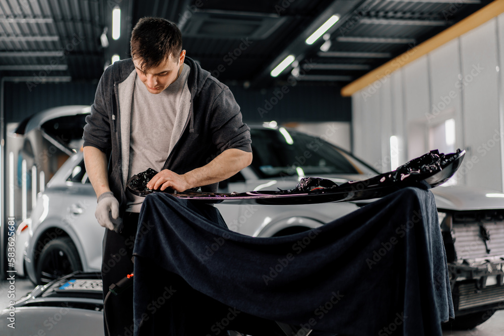 Gluing the film on the spoiler to protect the paint which protects the
