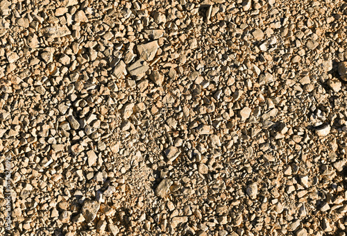 Fondo con detalle y textura de conjunto de pequeñas piedras y tierra, en tonos marrones