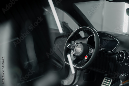 Car steering wheel Large details in the car interior Black leather interior Luxury car © Guys Who Shoot
