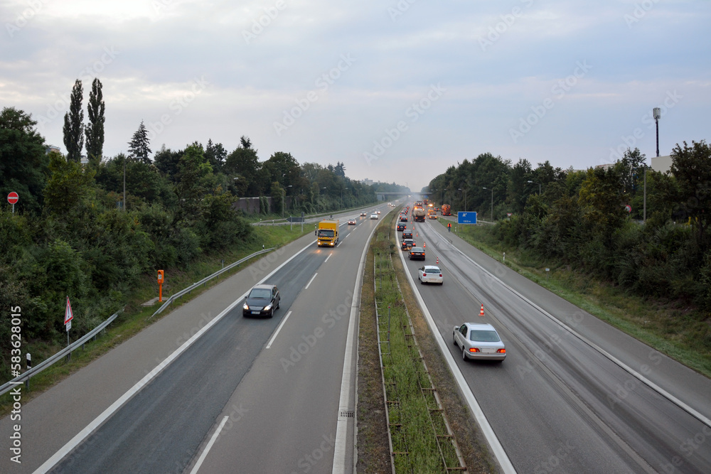 Traffic on the expressway. In the background, a remote control of the autobahn with the use of trucks and construction equipment. View from above