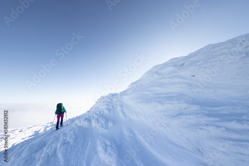 A woman walks in snowshoes in the mountains, winter trekking