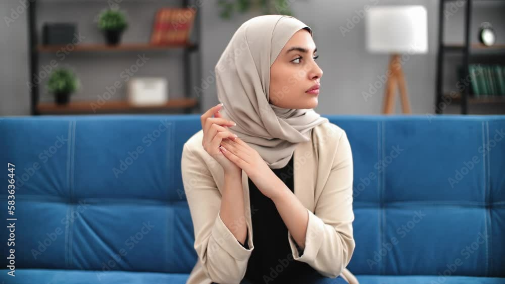 Saudi Turkish woman in hijab tired suffering head pain ache sick ill migraine headache at home couch Saudi Turkish woman in hijab tired suffering head pain ache sick ill migraine headache at home couch