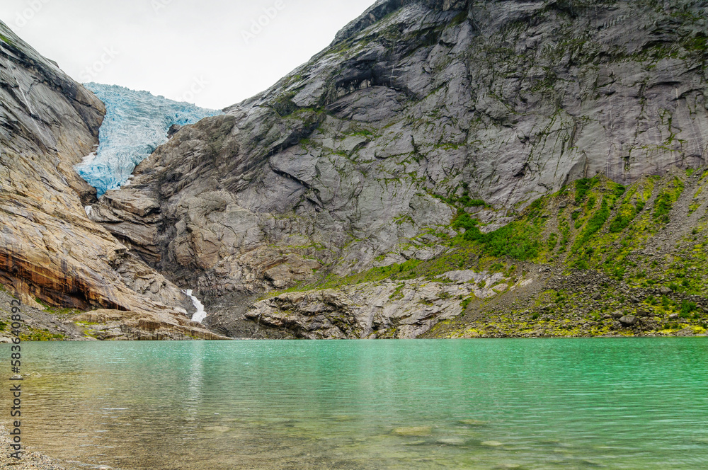 panoramic of the glacier with the ice waterfall falling down the mountain in Norway