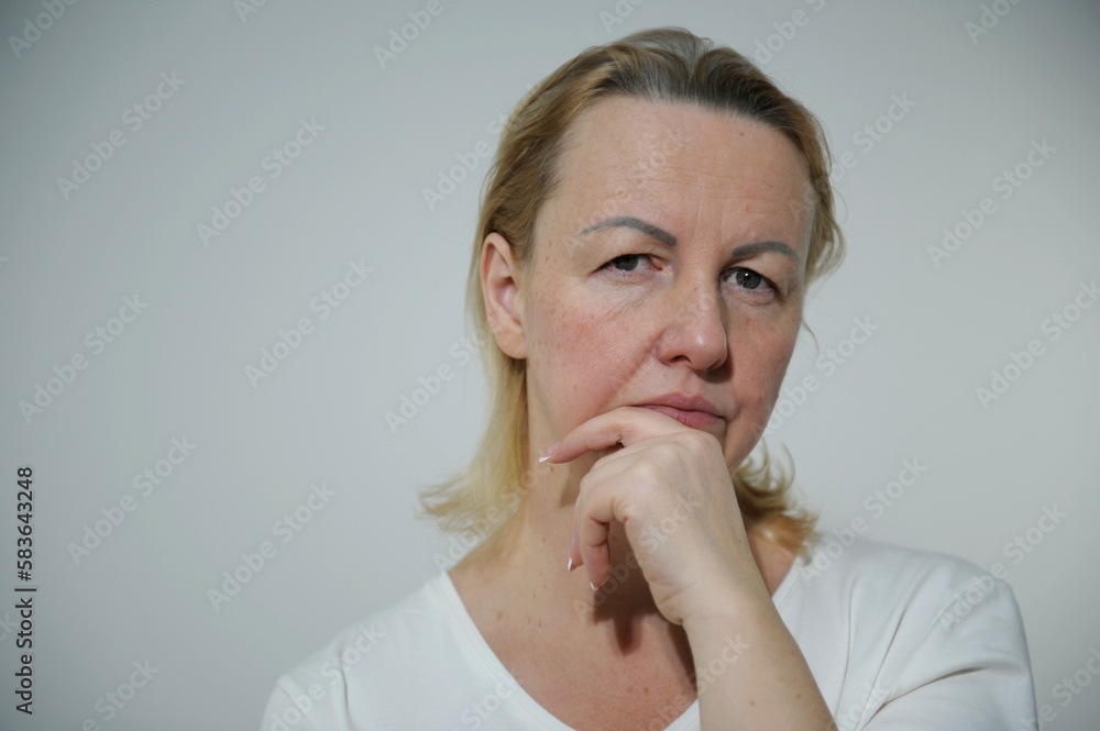 sad and calm look of a simple real woman unpainted hair need self-care eyes downcast with hand sad and calm look of a simple real woman unpainted hair need self-care eyes downcast with hand