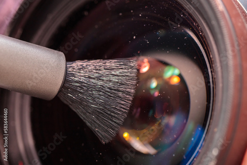 cleaning the objective lens from dust with a special brush. close-up.