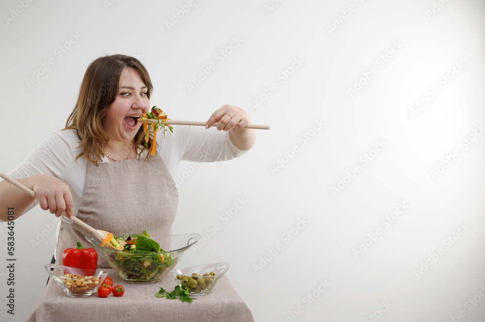 funny cheerful woman eating salad on white background she opens mouth wide bulges eyes large wooden spoon stuffs portion of food funny cheerful woman eating salad on white background she opens mouth wide bulges eyes large wooden spoon stuffs portion of food