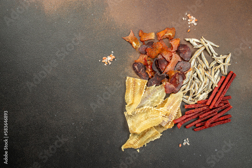 variety of dried fish, snacks for beer on a dark background. place for text, top view photo