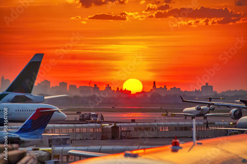 Backlit view of airplanes on the airport runway at sunset. Travel around the world concept