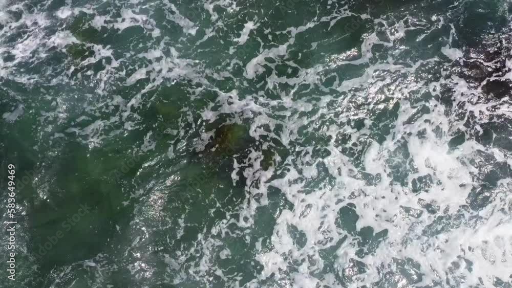 Aerial view from above of the sea waves at the rocky shore. Ocean coast. Calm beautiful video on the background for tourism, design and advertising Aerial view from above of the sea waves at the rocky shore. Ocean coast. Calm beautiful video on the background for tourism, design and advertising