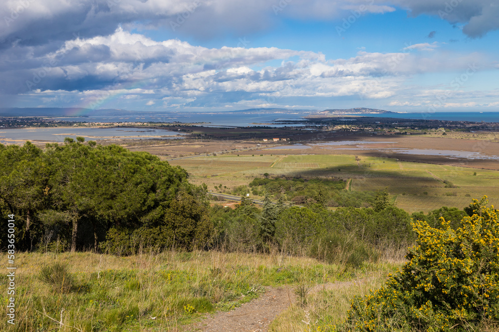 Vue sur la Réserve Naturelle du Bagnas et, au loin, sur le Mont Saint-Clair, par un temps nuageux depuis le Mont Saint-Loup à Agde