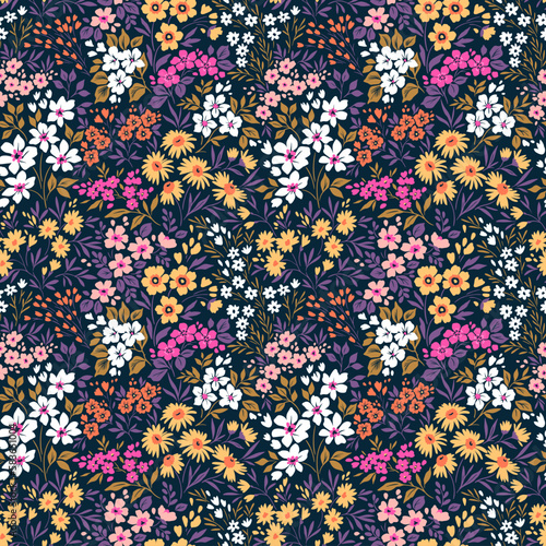 Beautiful floral pattern in small flowers. Small colorful flowers. Dark violet background. Ditsy print. Floral seamless background. Trendy template for fashion prints. Stock pattern.