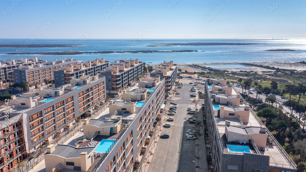 Fototapeta premium Aerial view of the Portuguese fishing tourist town of Olhao overlooking the Ria Formosa Marine Park. residential area with rooftop pool