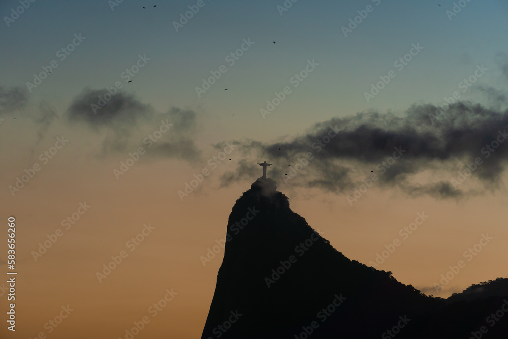 Sunset in the bay of Guanabara, cove and beaches of Rio de Janeiro, Brazil with its buildings, boats and landscape. Christ the Redeemer on top of Corcovado. Reflection of the sky in the sea