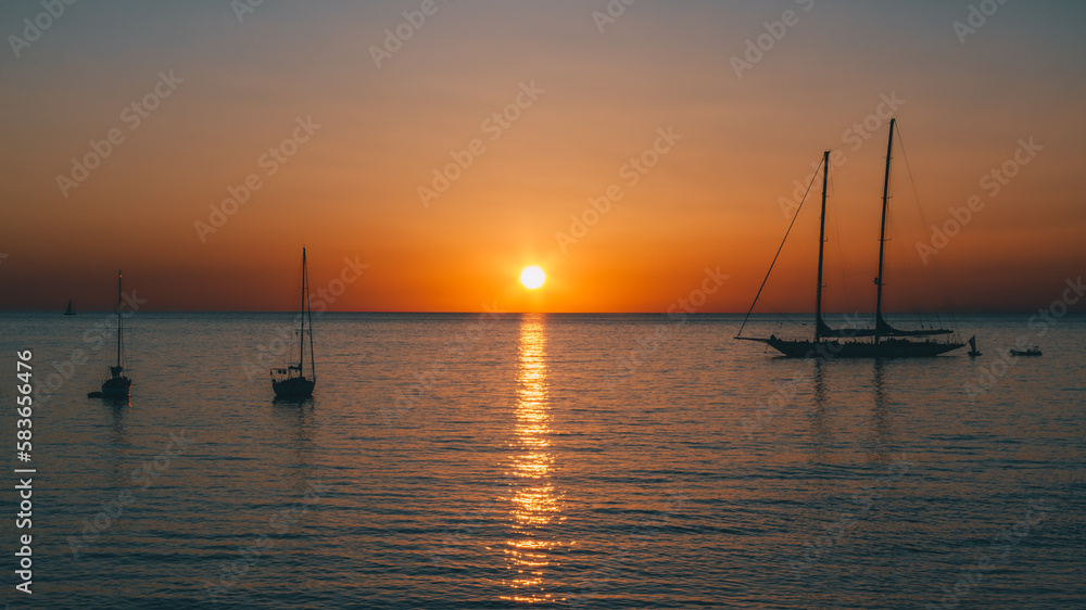 Un bateau sur l'océan au coucher de soleil orange