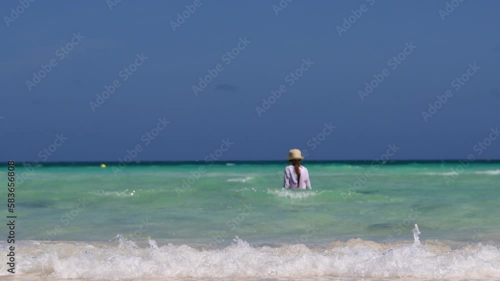 The girl swims in the sea, goes to the depth.The water in the ocean is a beautiful blue color.Family vacation in a hotel on the coast.The child enters the water, the waves roll onto the shore The girl swims in the sea, goes to the depth.The water in the ocean is a beautiful blue color.Family vacation in a hotel on the coast.The child enters the water, the waves roll onto the shore