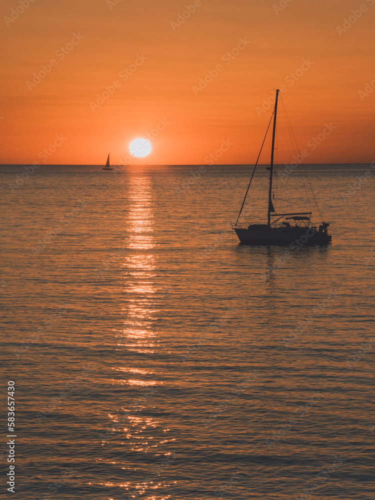 Un bateau sur la mer au coucher de soleil orange