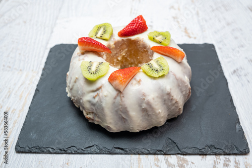 Obraz na płótnie A gugelhupf (kuglof) with fruits on a black plate w salonie