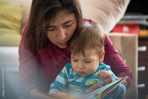 Obraz na płótnie Mother And Baby Son Reading Book Together w salonie