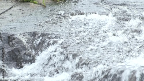 Water cascades and flows over river rocks