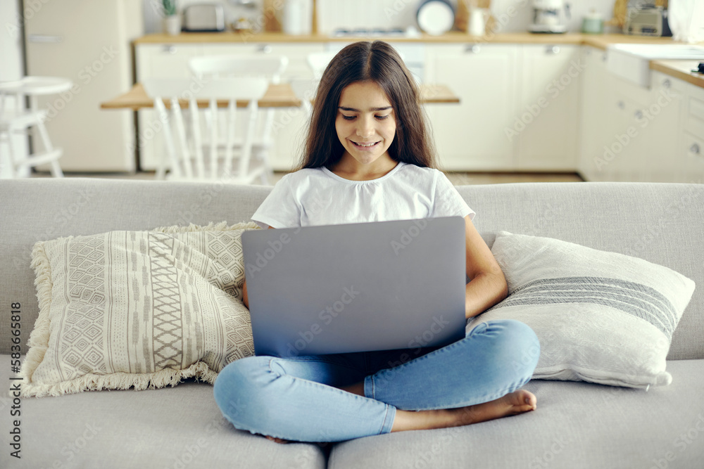 Cute 12s girl use laptop sit on sofa in living room Cute 12s girl use laptop sit on sofa in living room