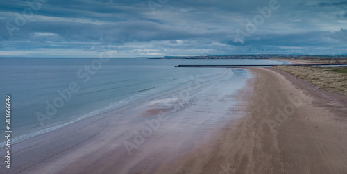 Aerial drone picturesque panorama of sandy beach at Castlerock, Northern Ireland on cloudy spring day. Dark clouds, wind and low tide at Castlerock coastal town. © Anze