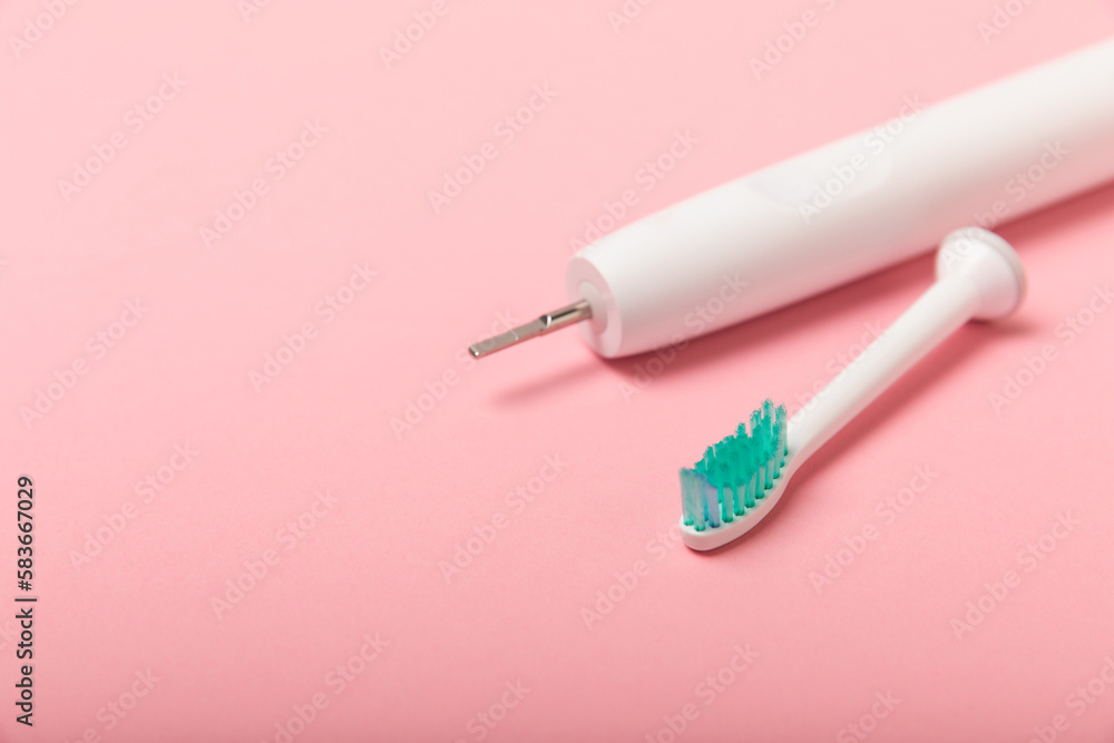 Smart electric toothbrush on a pink background.Modern technologies for health. Healthy teeth. Dentistry concept. Charged via powerbank and controlled by an app on a smartphone. Oral hygiene. Smart electric toothbrush on a pink background.Modern technologies for health. Healthy teeth. Dentistry concept. Charged via powerbank and controlled by an app on a smartphone. Oral hygiene.