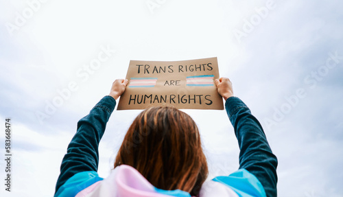 Transgender woman fighting for trans human rights at gay pride protest holding banner - People celebrating LGBTQ event concept photo