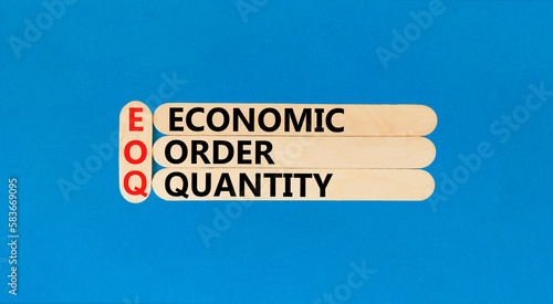 EOQ economic order quantity symbol. Concept words EOQ economic order quantity on wooden stick on a beautiful blue table blue background. Business EOQ economic order quantity concept. Copy space. photo