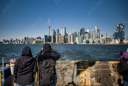 Photography two tourists taking a picture from ferry in lake ontario of toronto skyline