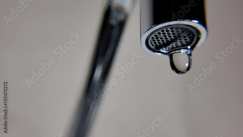 Drops of water, water drops falling from a faucet in slow motion, 4k, natural light, selective focus.