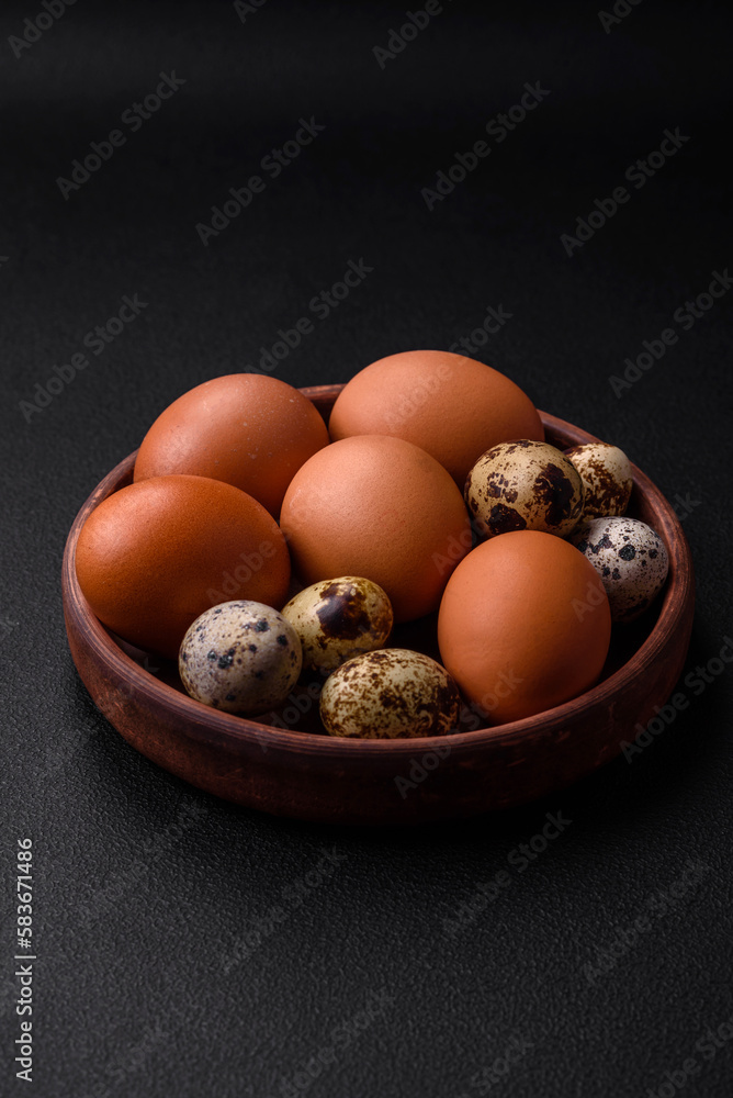 Raw chicken and quail eggs in a brown ceramic bowl on a dark concrete background Raw chicken and quail eggs in a brown ceramic bowl on a dark concrete background