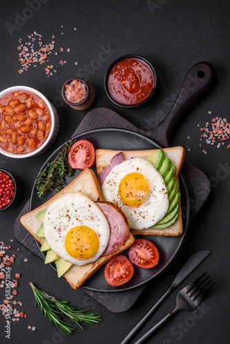 Delicious nutritious English breakfast with fried eggs, tomatoes and avocado