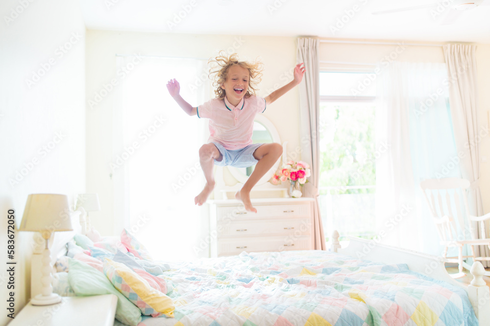 Child playing in bed. Kids room. Boy at home.